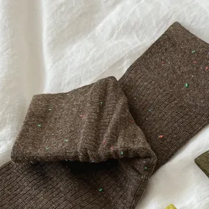 Vista ravvicinata di calze slouch in maglia marrone strutturata con dettagli multicolore.