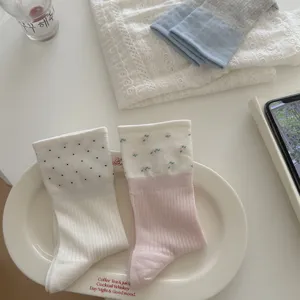 Detailed shot of thin breathable women's socks with cute floral and polka dot designs.
