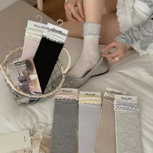 Detail shot of Japanese sweet ruffle mid-tube socks, solid color stacked cotton sock display.