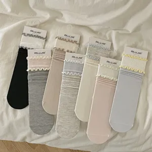 Close-up detail of cute ruffled mid-calf socks featuring vertical stripes and pastel tones.