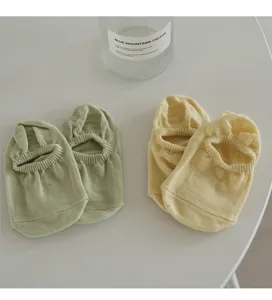 Close-up detail of lightweight candy-colored invisible shallow socks, minimalist aesthetic.