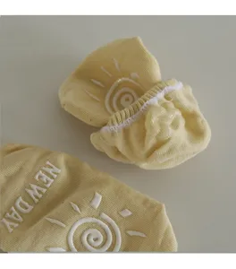 Detailed view of yellow baby anti-slip socks featuring cute sun silicone grips and print.