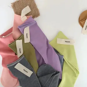 Detailed view of women's combed cotton mid-tube candy color socks with brand tags.