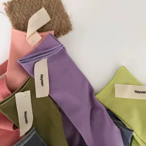 Detail shot of colorful combed cotton rolled cuff mid-tube socks in pastel shades.