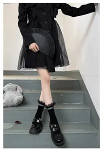 Detail shot of black mid-calf socks featuring delicate ruffled lace cuffs, sweet gothic style.