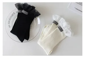 Detailed shot of Japanese style mid-tube socks with elegant tulle ruffles and cute fabric labels.