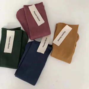 Detailed shot of ribbed mid-calf cotton socks in multiple candy colors with tags.