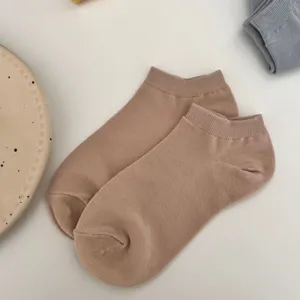 Detailed close-up of solid color beige short boat socks, breathable summer ankle socks.