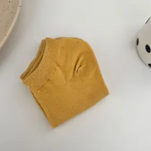 Close-up detail of a folded solid yellow women's short boat sock showcasing soft cotton fabric texture.