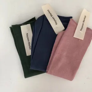 Detail shot of ribbed cotton mid-tube socks in green, blue, and pink, breathable everyday wear.