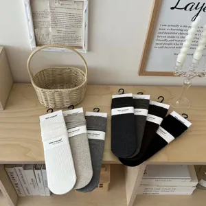 Detailopname van geribbelde katoenen sokken netjes gepresenteerd op houten tafel.