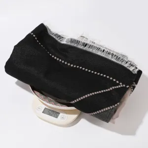Classic black knit scarf with fringe and geometric diamond pattern, elegant winter accessory.