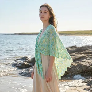 Detailansicht der gestrickten Strandtuch-Umhangs am Meer mit einer sehr feinen offenen Stricktextur.
