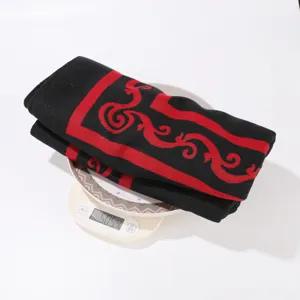 Nahaufnahme von ethnischem Strick-Cape Detail mit schwarz-roter Webmuster Textur und Gewicht.