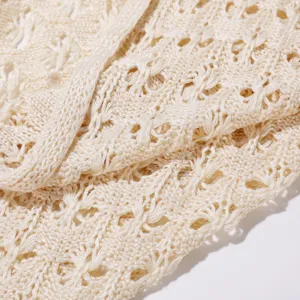 Primer plano detallado de tela de punto beige con una textura de malla fina y delicada.