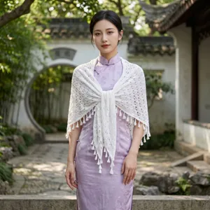 Vista detallada de un chal triangular de punto blanco con flecos sobre un vestido qipao.