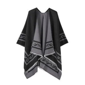 Nahaufnahme eines schwarz-grauen Strickschals mit Mustern und Fransen am Saumrand.