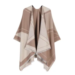 Close-up detail of the stylish color-block cape featuring delicate fringe and soft texture.