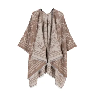 Detail des eleganten braunen Jacquard-Capes mit aufwendigen Vintage-Mustern und Fransen.