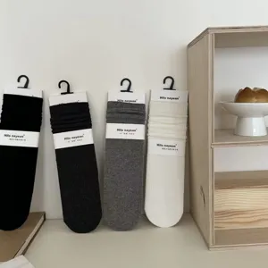 Detailopname van zachte katoenen slouch-sokken voor dames met geribbelde textuur en naadloos ontwerp.