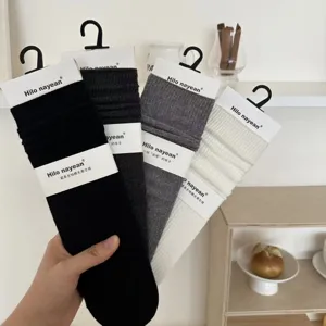 Detailopname van meerkleurige geribbelde katoenen slouch sokken voor dames met labels.