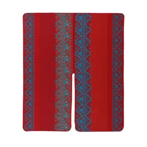 Vista dettagliata del poncho rosso con motivi geometrici blu e tessuto morbido.