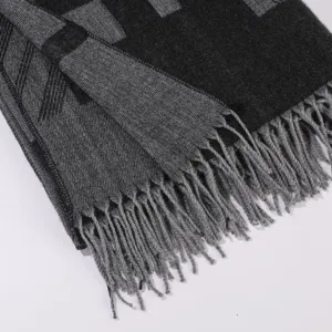 Primo piano dettagliato di sciarpa foulard in maglia con motivo geometrico e frange.