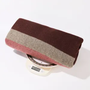 Detailed view of the color-blocked knit shawl, showing its weight and soft wool texture for winter.