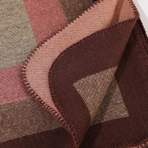 Close-up detail of women winter knit shawl, showing soft textured plaid fabric and fine edging.