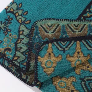 Detailopname van een etnische geweven damessjaal met turquoise en gouden patronen.
