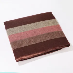 Detail view of warm knitted striped shawl, cozy winter outerwear cape for daily fashion style.