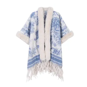 Detailansicht des blauen Cape mit Fellkragen, Kunstfellbündchen und fransigem Saum.