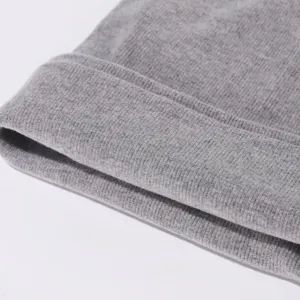 Gros plan sur les details du cache-cou en tricot côtelé gris doux et confortable.