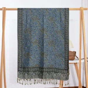 Gedetailleerd overzicht van de blauwe sjaal met kasjmier motief op een houten standaard.