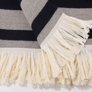 Close-up knit striped scarf with white fringe detail, cozy winter shawl texture display.