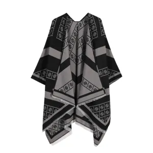 Detailopname van de zwart-met-grijze jacquard paisley patroon cape met stijlvolle franje rand.