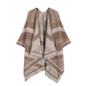 Detailopname van de stijlvolle bruin-beige paisley jacquard franje cape en modieuze sjaal.
