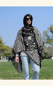 Primo piano della elegante mantella con cappuccio a motivi geometrici bianco e nero.