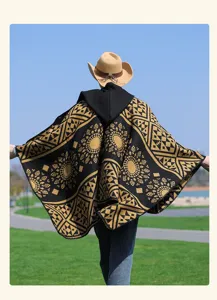 Primo piano del poncho vintage con cappuccio da donna con motivo geometrico nero e giallo.