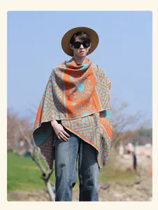 Dettaglio poncho in maglia moda all'aperto, scialle mantello con motivo etnico arancione.