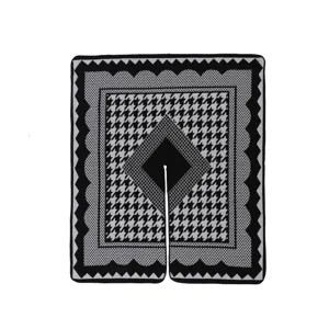 Detaillierte Nahaufnahme des schwarz-weißen Hahnentritt Strickcape mit feiner Textur.