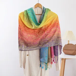 Detail van regenboog paisley jacquard sjaal met mooi kleurverloop en fijne franjes.