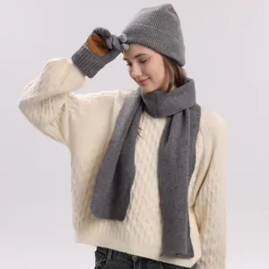 Vista detallada del conjunto de gorro bufanda y guantes de punto gris con lana.