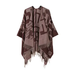 Vista dettagliata della mantella scialle da donna in maglia geometrica marrone con frange.
