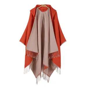 Detailed view of the women's stylish knitted hooded poncho with fringe and dual-color design.