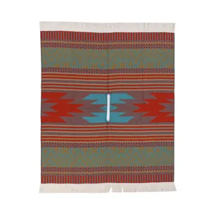 Detail des gewebten Fransen-Capes im Ethno-Stil, gemusterter Strickponcho für gemütliche Reisen.