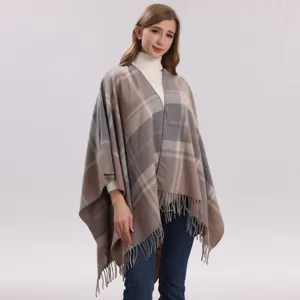 Gedetailleerd uitzicht op de geruite winter sjaal cape met franje zoom en warm design.
