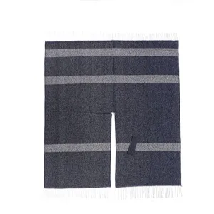 Nahaufnahme des dunkelblauen Strickcape mit horizontalen Streifen und Fransensaum.