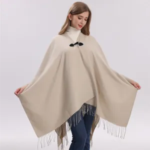Poncho cape en tricot beige pour femme avec bouton et franges, vêtement hiver chaud.