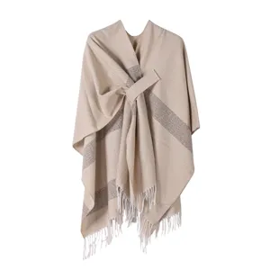 Detailansicht des warmen Strick-Ponchos mit schickem Wickelgurt und elegantem Fransensaum.